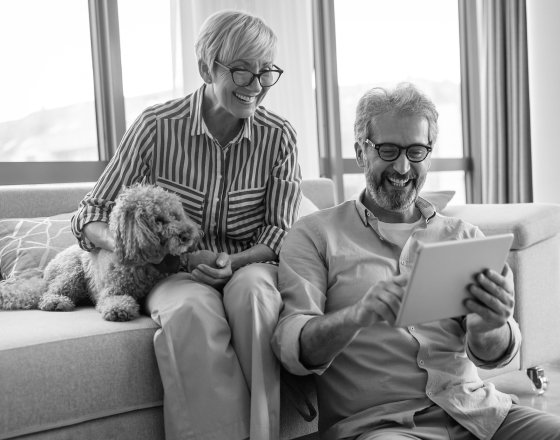 Ilustración pareja mayor con perro viendo una tablet